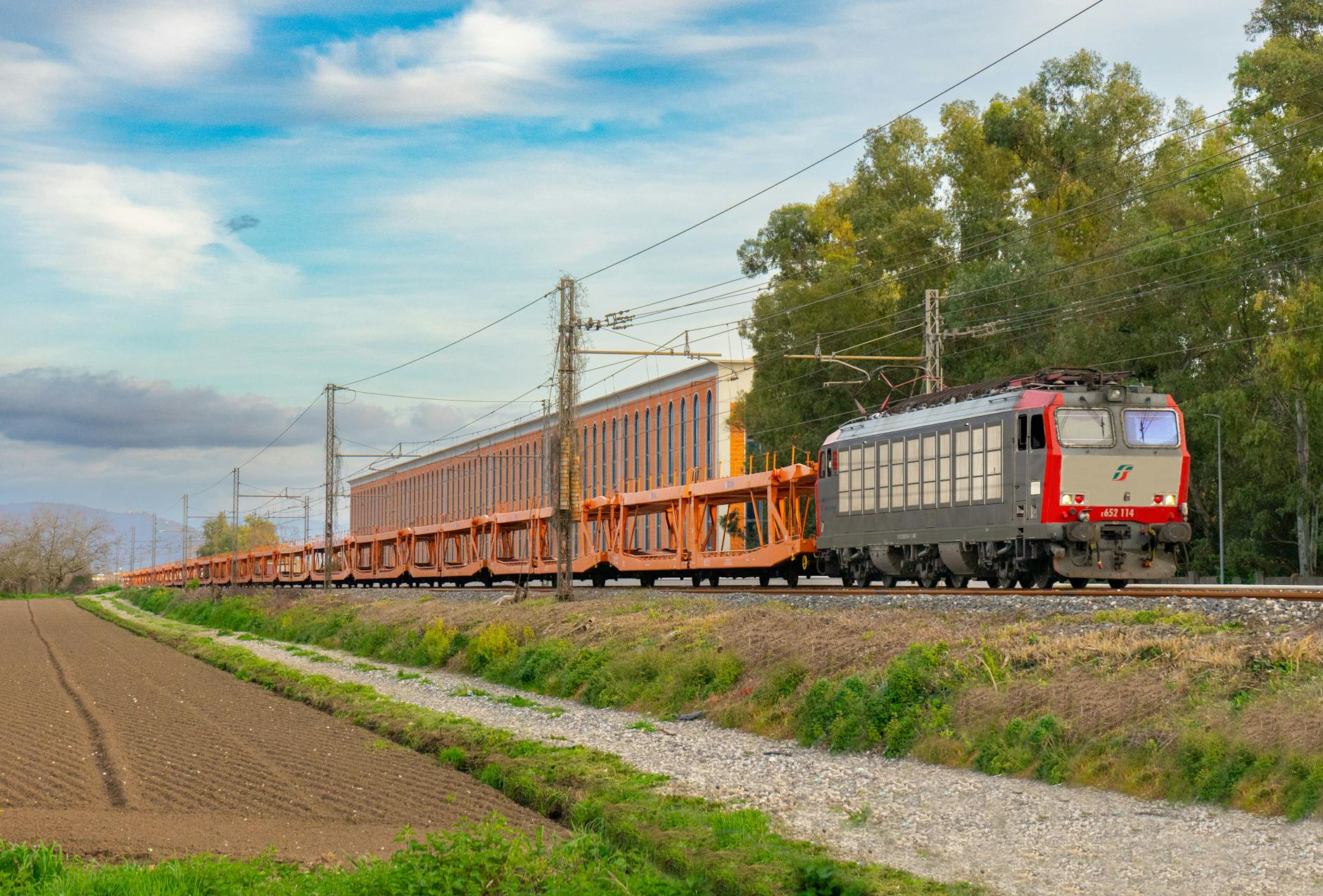 Pociąg towarowy jedzie przez zielone pola na południu Włoch