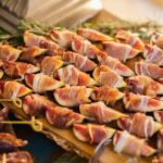 Półmisek fig zawiniętych w prosciutto di Parma z oliwkami